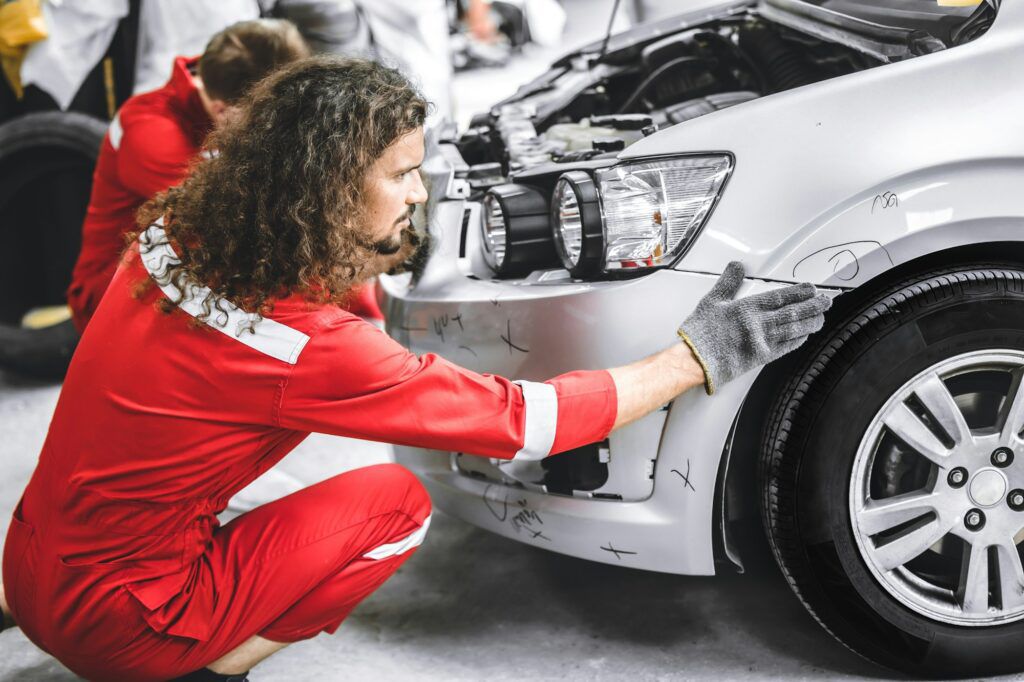 Collision insurance concept showing car repaired in auto shop.